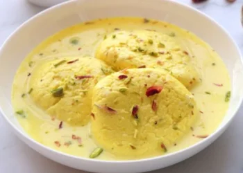 Ras Malai, a quintessential Indian dessert, is a spongy and creamy delight prepared with fresh cheese called 'chhena'. The chhena is cooked in sugar syrup and soaked in a cardamom-flavored sweet milk syrup known as 'rabdi', adorned with chopped almonds and pistachios.